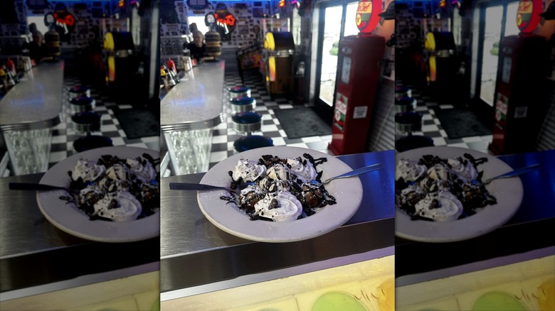 Ice cream sundae dish with dining area with checkerboard flooring and counter seating at Hot Rods 50's Diner