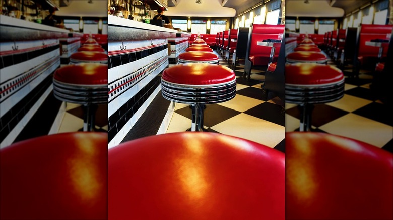 Interior dining area with red bar stool at counter seating at Oakley Diner