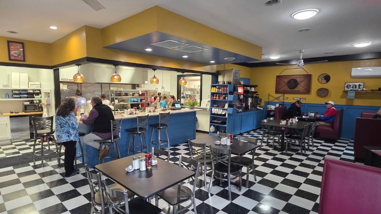 Interior dining area with checkerboard flooring and counter seating at the Damascus Diner