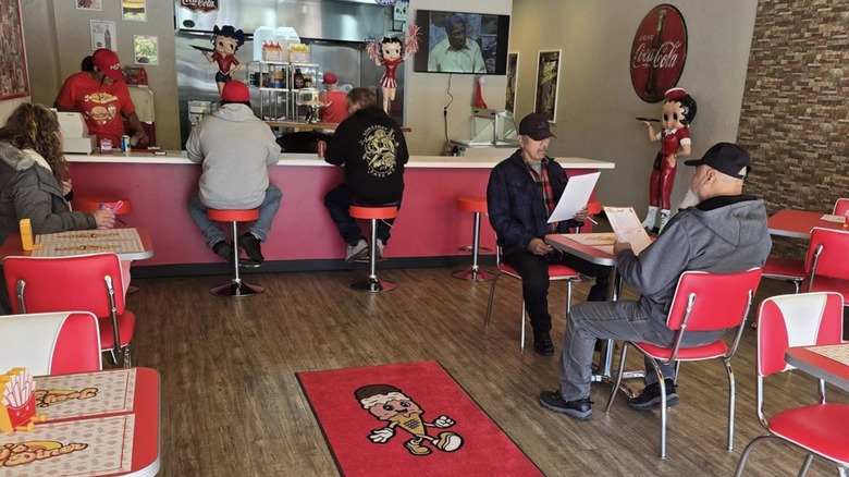 Interior dining area with counter bar seating and small tables at Joey's Diner