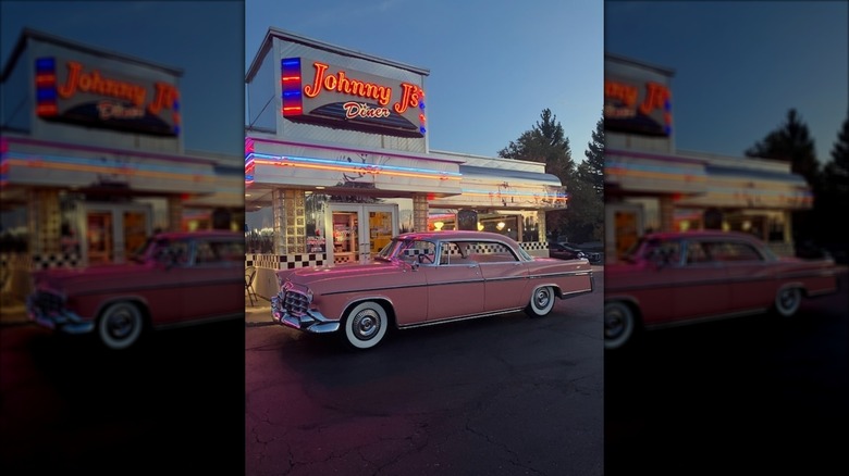 Exterior of Johnny J's Diner with neon sign and a retro pink cadillac parked in front