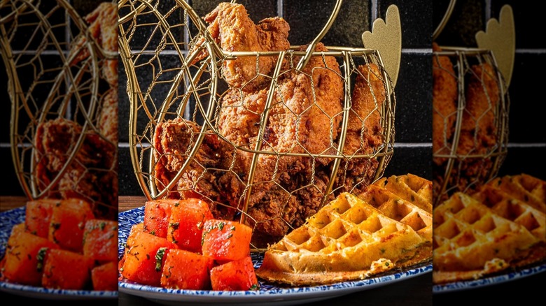 Chicken and Waffles at Yardbird Table & Bar with the chicken in a metal, chicken-shaped wire basket and the remainder on a blue and white plate