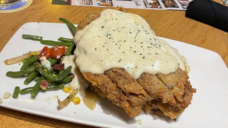 Chicken Fried Steak with side of vegetables at Twin Peaks on a white plate