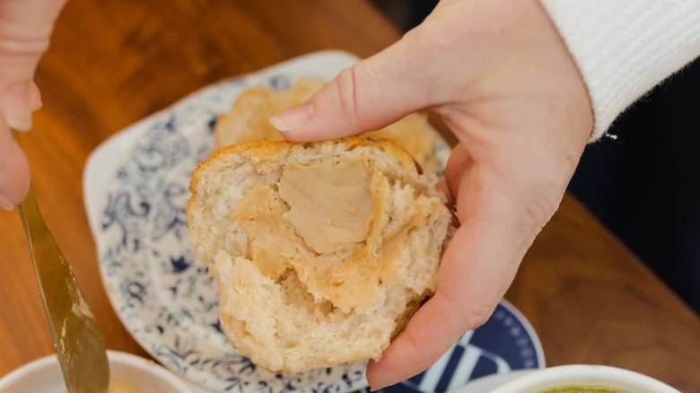 Hand holding a biscuit with spread