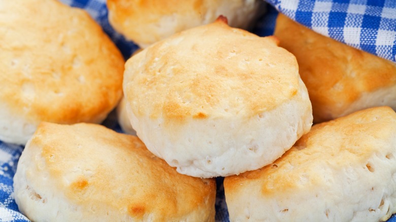 Buttermilk biscuits nestled on top of a checkered blue and white cloth