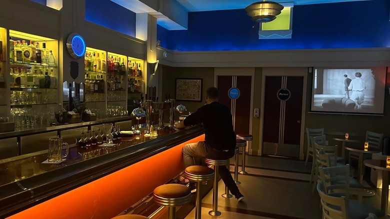 Bar with barstools and patron sitting at it at Stookey's Club Moderne