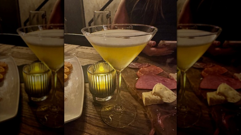 Martini glass drink with a charcuterie board at a candlelit table at The Barrel Bar