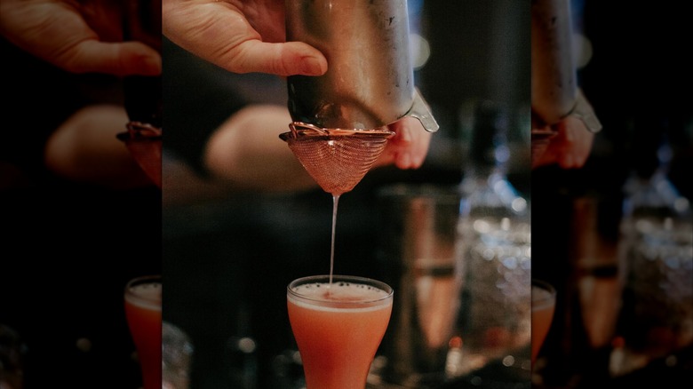Cocktail drink being poured through strainer at 21st Amendment Bar at La Louisiane