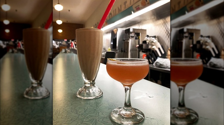 Milkshake alongside a cocktail sitting on the bar at The Apothecary at Brent's Drugs