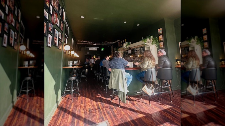 patrons enjoying drinks in the cozy interior with bar seating at Goodnight Kenny
