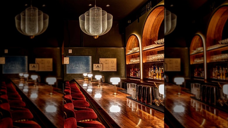 Vintage-inspired bar with red velvet bar seating and a lovely chandelier at The Red Ribbon Society