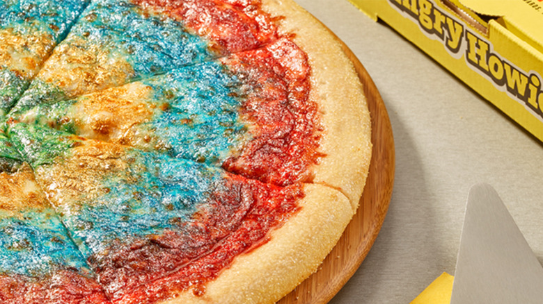 Tie Dye pizza from Hungry Howie's on a wood platter next to a pizza box.
