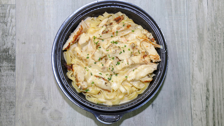 A to-go container of chicken alfredo.