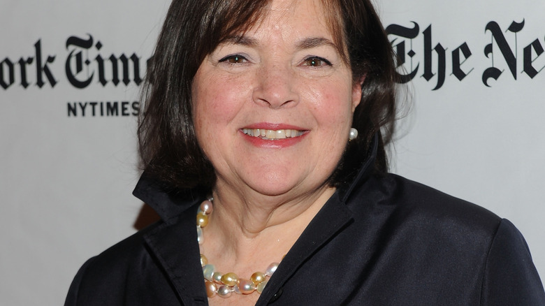 Ina Garten smiles in pearls and a black outfit at an event