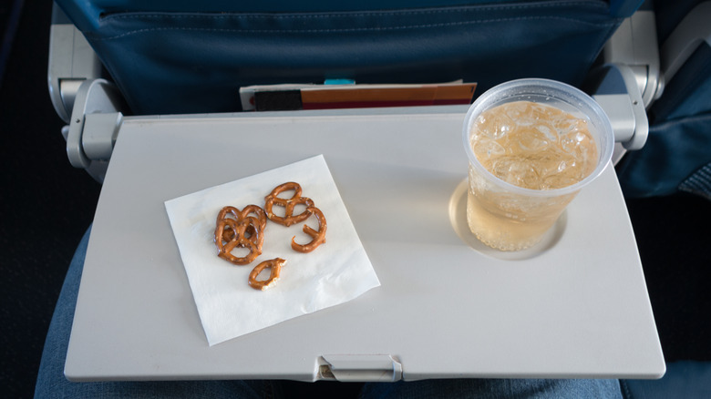 soda and pretzels on airplane tray