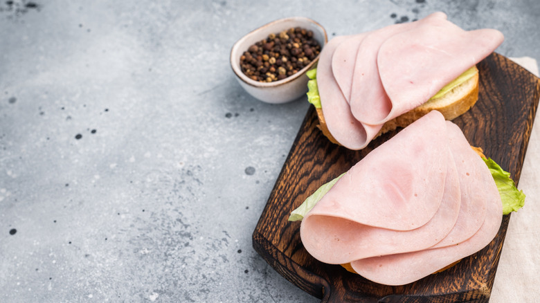 Freshly made open faced ham sandwich on artisanal bread and wooden cutting board