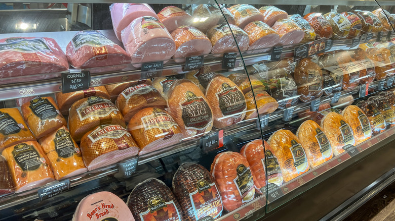 Deli counter window with various types of whole deli meats in case