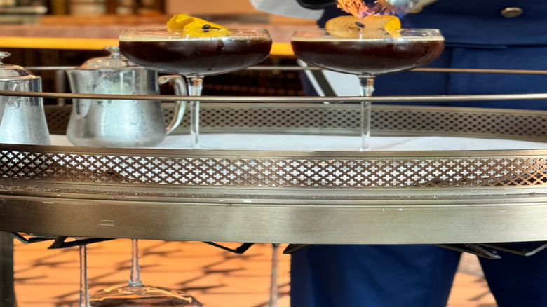 Bartender garnishing espresso martinis with torched citrus