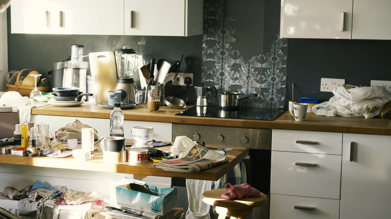 cluttered kitchen with counters covered with miscellaneous items