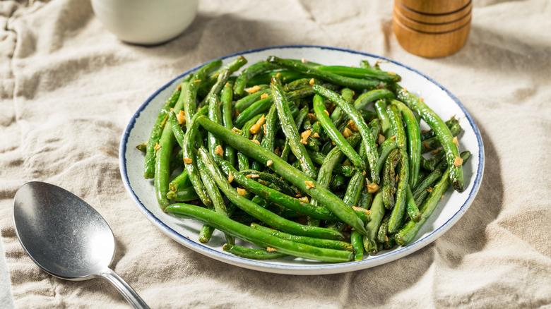 blistered green beans on plate with spoon