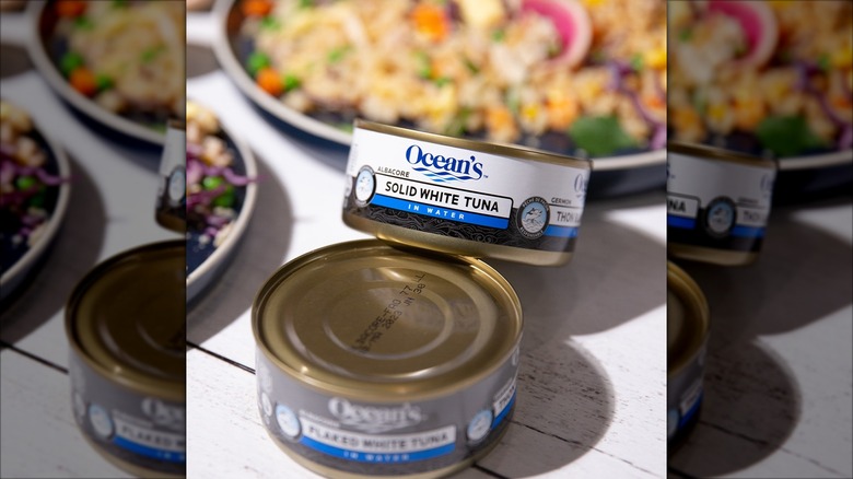 Cans of Ocean's tuna on table by dishes