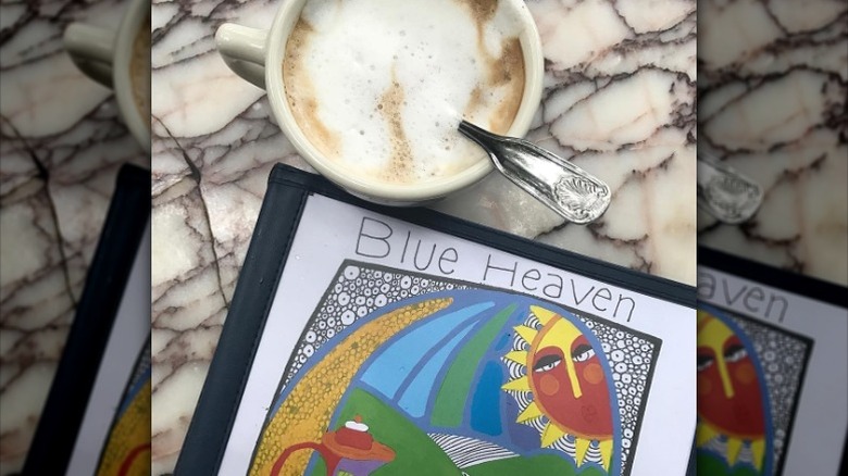 The breakfast menu for Blue Heaven, alongside a cup of coffee.