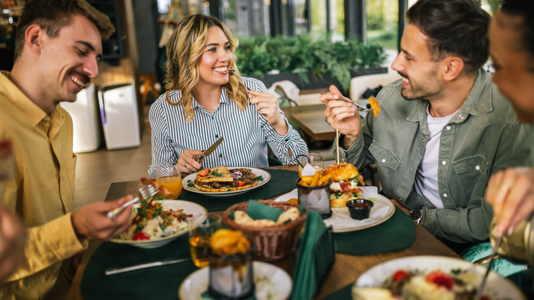 A group of adults dining at a table and eating