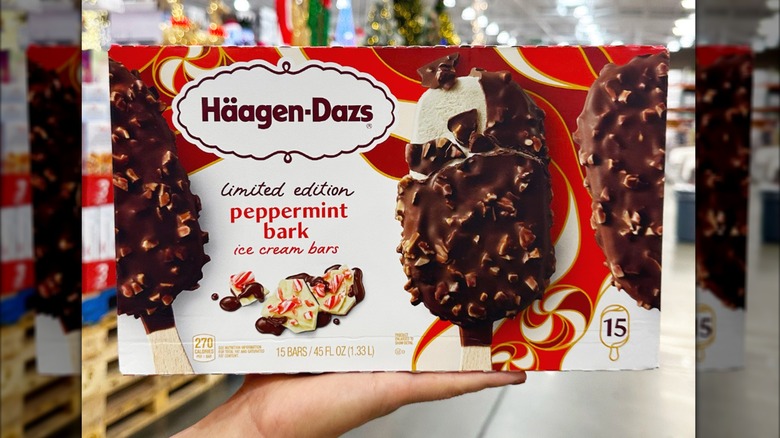 Costco shopper holds a box of Häagen-Dazs Peppermint Bark Ice Cream Bars inside the store