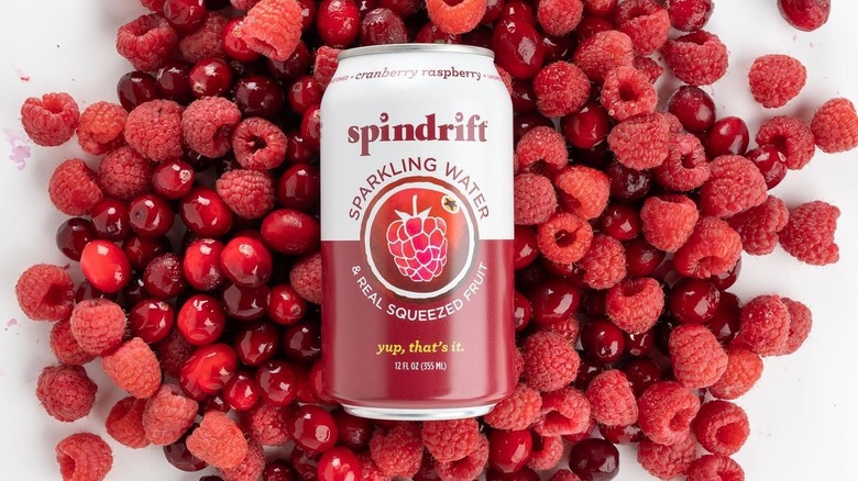 A can of Spindrift cranberry raspberry sparkling water with fresh berries