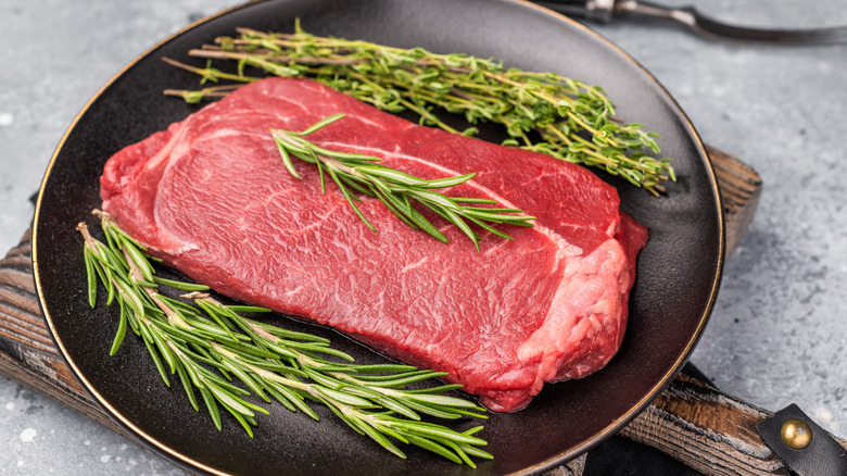 Raw sirloin in pan on a cutting board