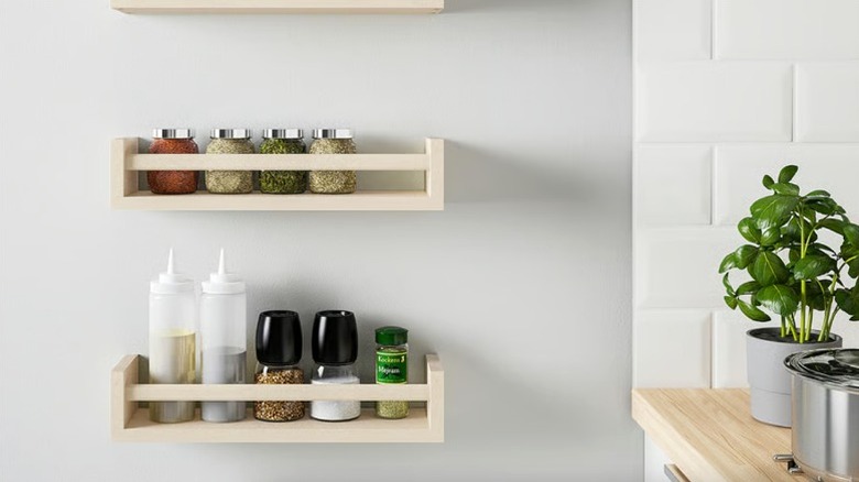 IKEA BEKVÄM spice racks holding spices and cooking oils on wall in modern kitchen