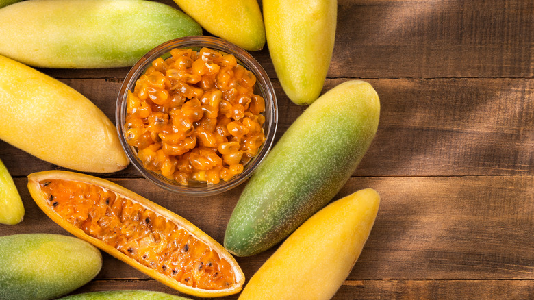 Banana passionfruits on wood; pulp in bowl