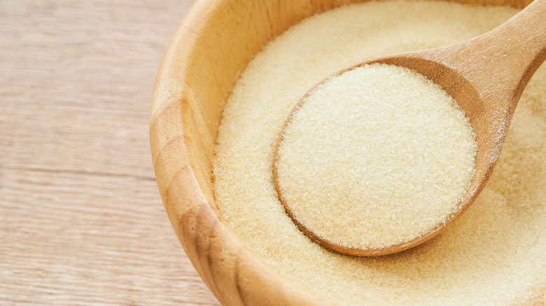 Gelatin powder in a wooden bowl with a wooden spoon