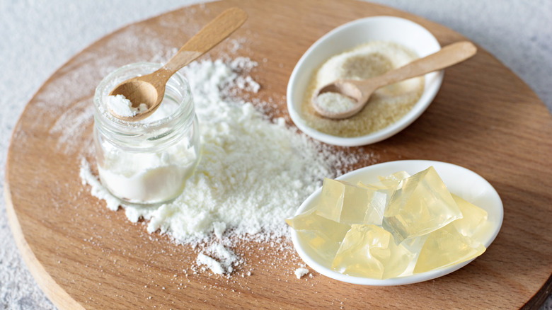 Three types of stabilizers pictured with wooden spoons on a wooden board, including gelatin cubes
