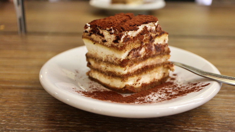 Tiramisu, a popular Italian dessert, on a plate inside a restaurant