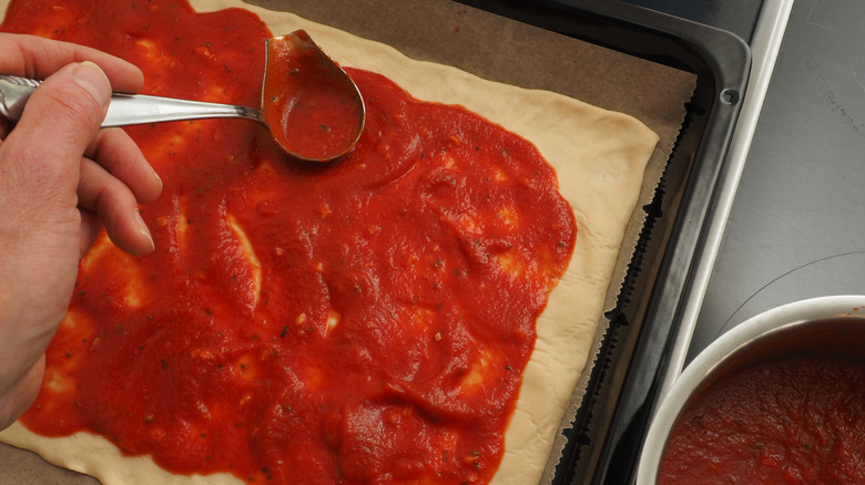 Preparing homemade pizza with passata