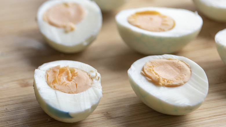 Halved hard-boiled eggs on a wooden surface