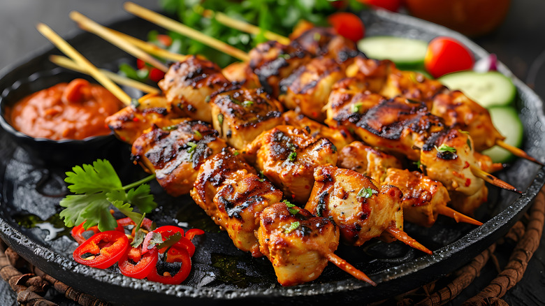 grilled chicken skewers on a black plate