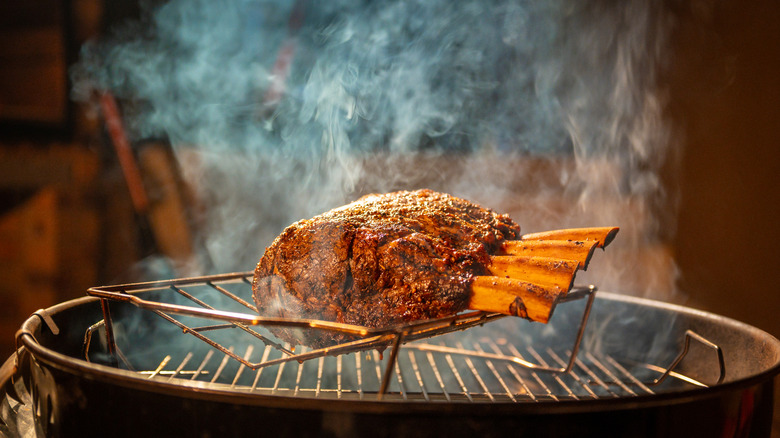 meat smoking on a charcoal grill at night