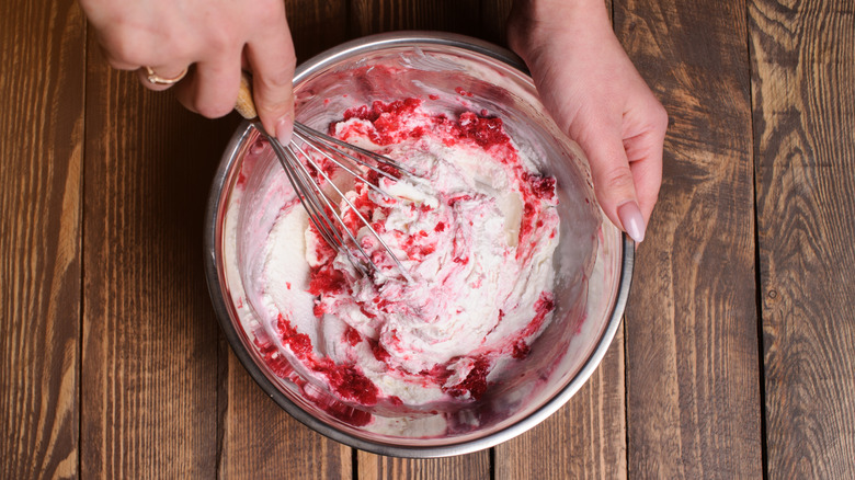 A home cook whisks berries into homemade ice cream