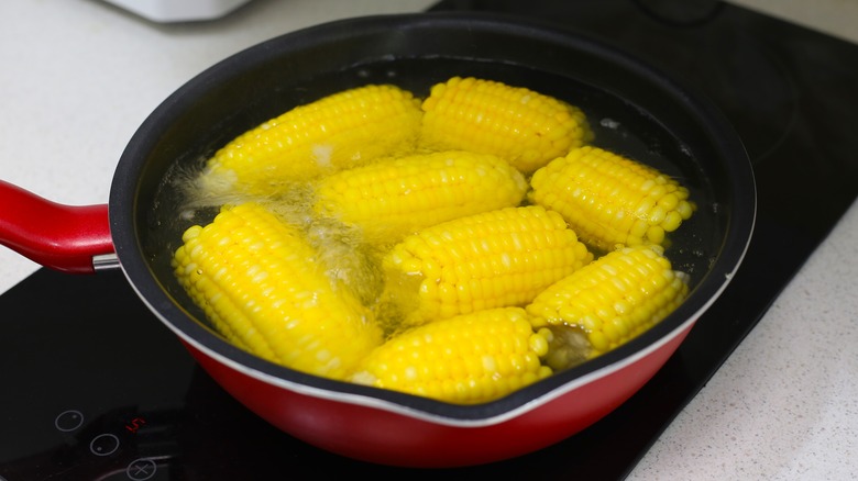 corn cobs in a pan of water