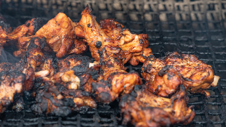 Jerk chicken smokes inside an oil drum