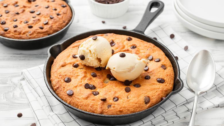 A chocolate chip skillet cookie topped with vanilla ice cream