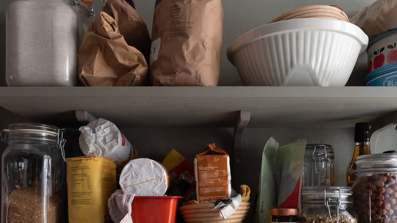 Two kitchen pantry shelves with dry goods and containers