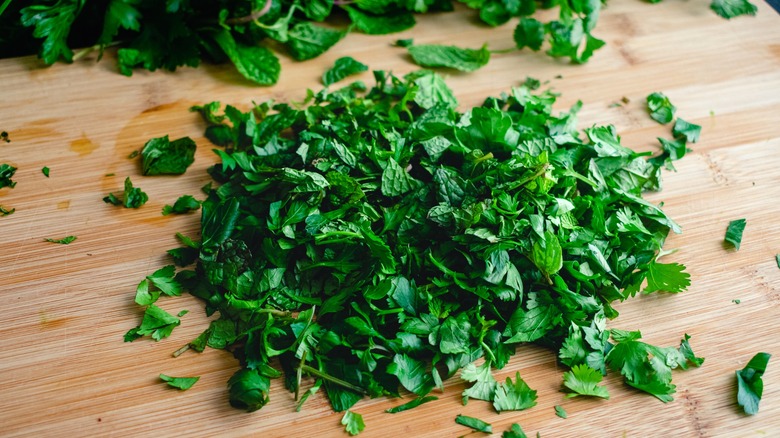 Pile of chopped herbs on wood cutting board