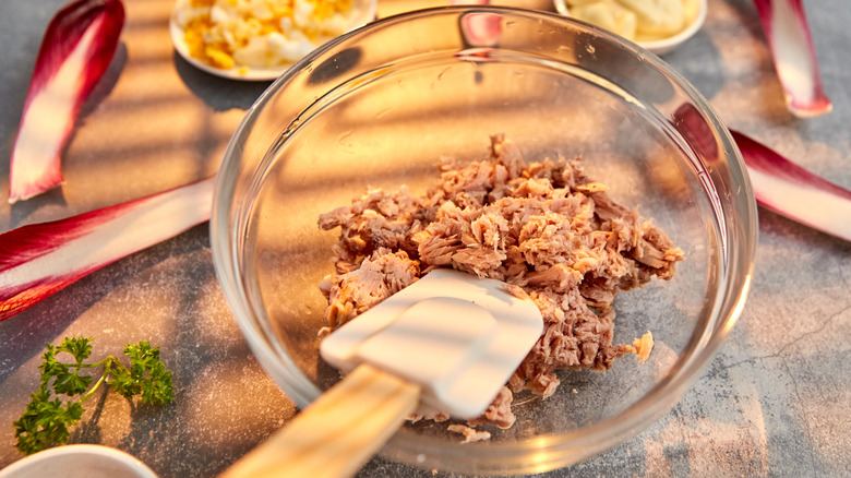 Glass bowl with drained tuna and a spatula