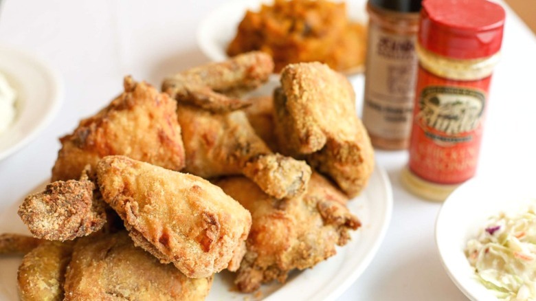 A plate of fried chicken next to spice jars on a table at Zehnder's