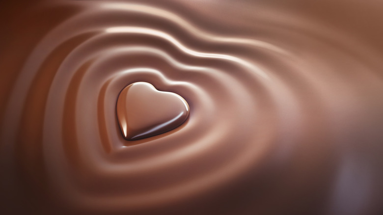 Melted chocolate waves around a chocolate heart.
