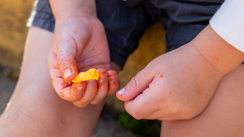 A child's hands covered in Cheetle