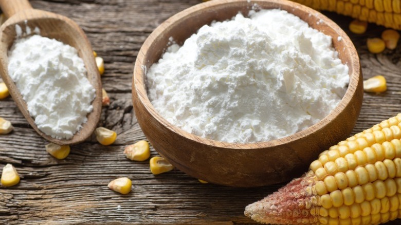 A bowl of cornstarch next to an ear of corn